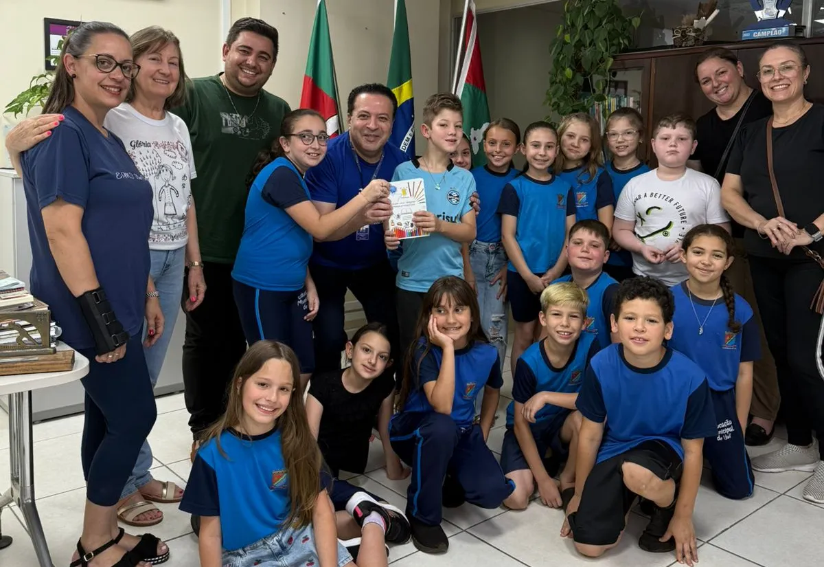 Turma do 3º ano da EMF Davi Canabarro entrega publicação ao secretário de Educação